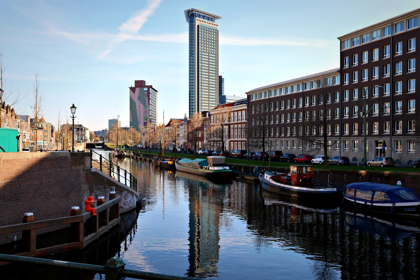 Gracht met woonboten en stadstoren gespiegeld in het water