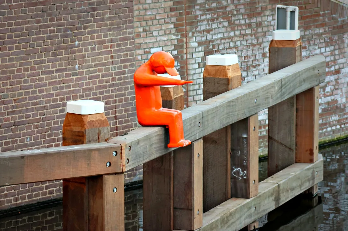 Oranje kunstsculptuur op een brug in de buurt